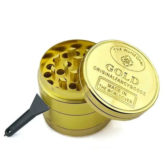 Gold herb grinder with open compartments and a small scraper, made of zinc alloy, 40mm size.