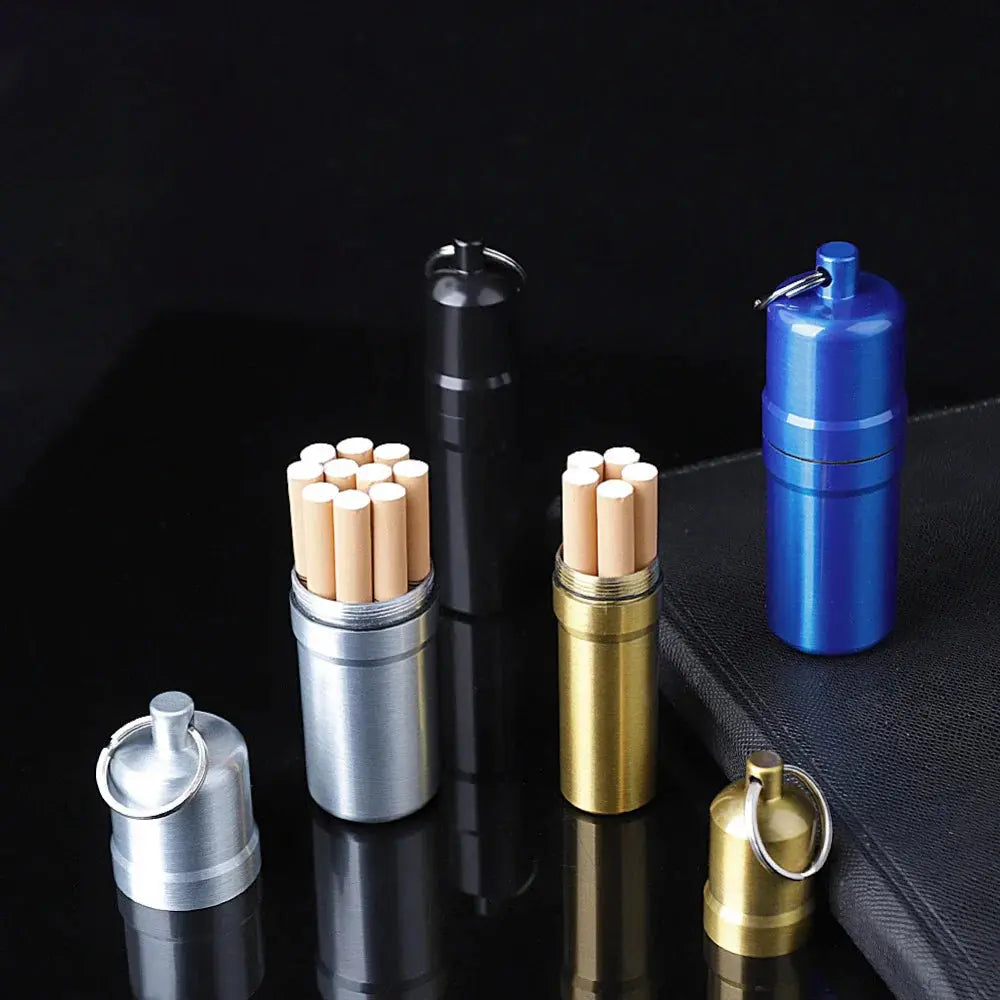 Metal cigarette cases with keychain in silver, black, gold, and blue colors, displayed with cigarettes.