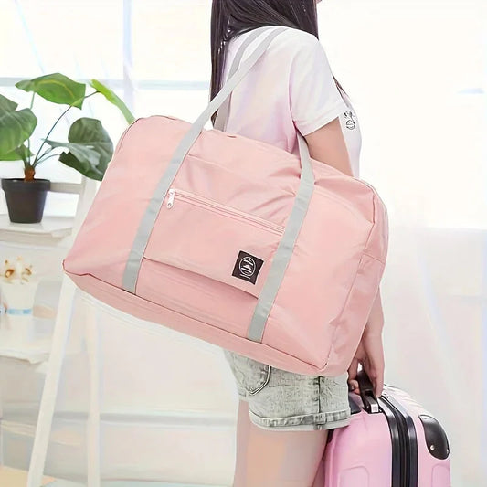Lightweight foldable travel duffel bag in pink nylon with large capacity and shoulder straps for women and girls.