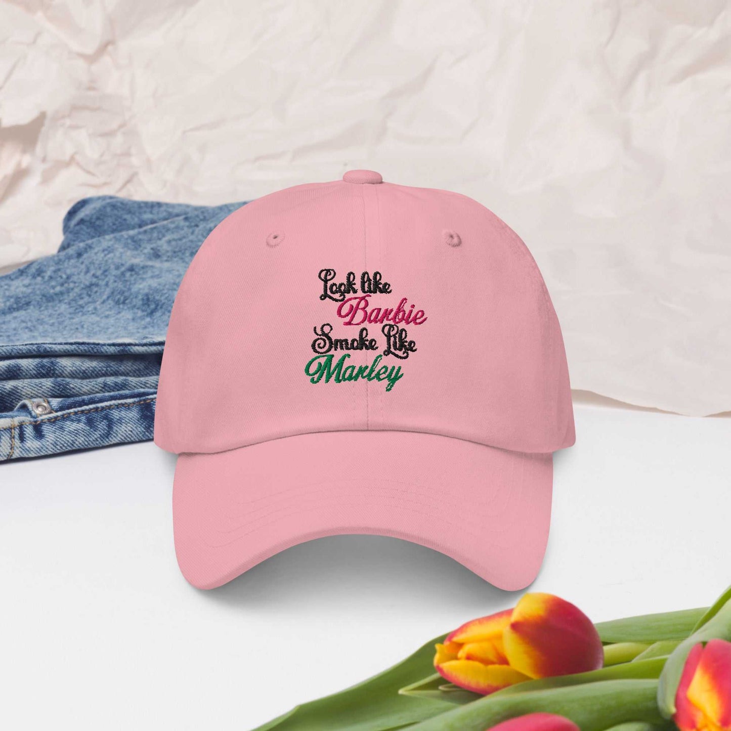 Pink Barbie Marley Hat with adjustable strap and curved visor on a table.