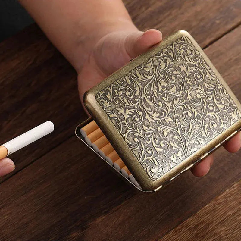 Vintage metal cigarette case with intricate design, holding 20 cigarettes.