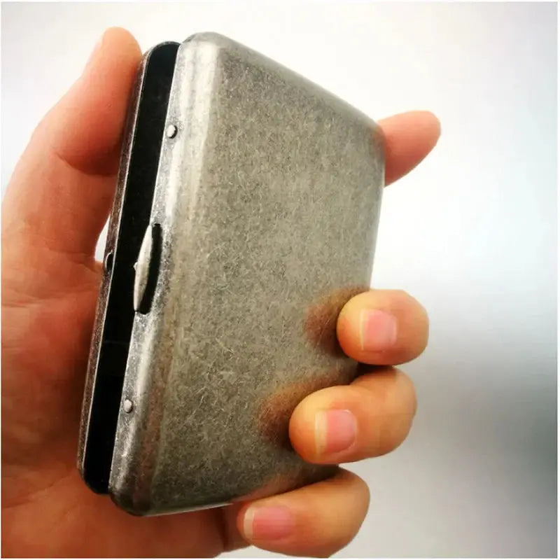 Vintage metal cigarette case for 20 pieces, classic design, held in hand.