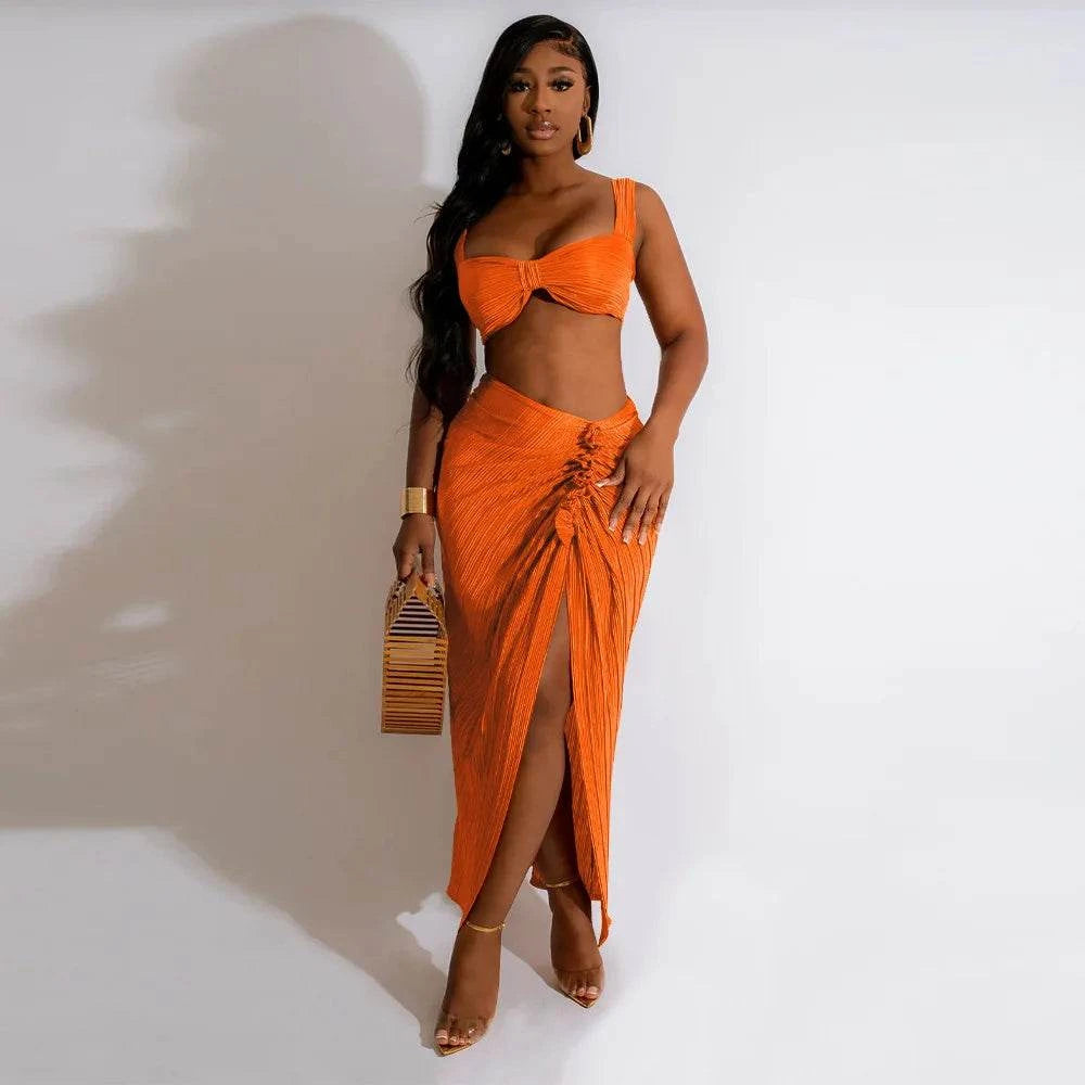 Summer orange two-piece set for women, featuring a sexy backless halter top and high waist side slit pleated skirt.