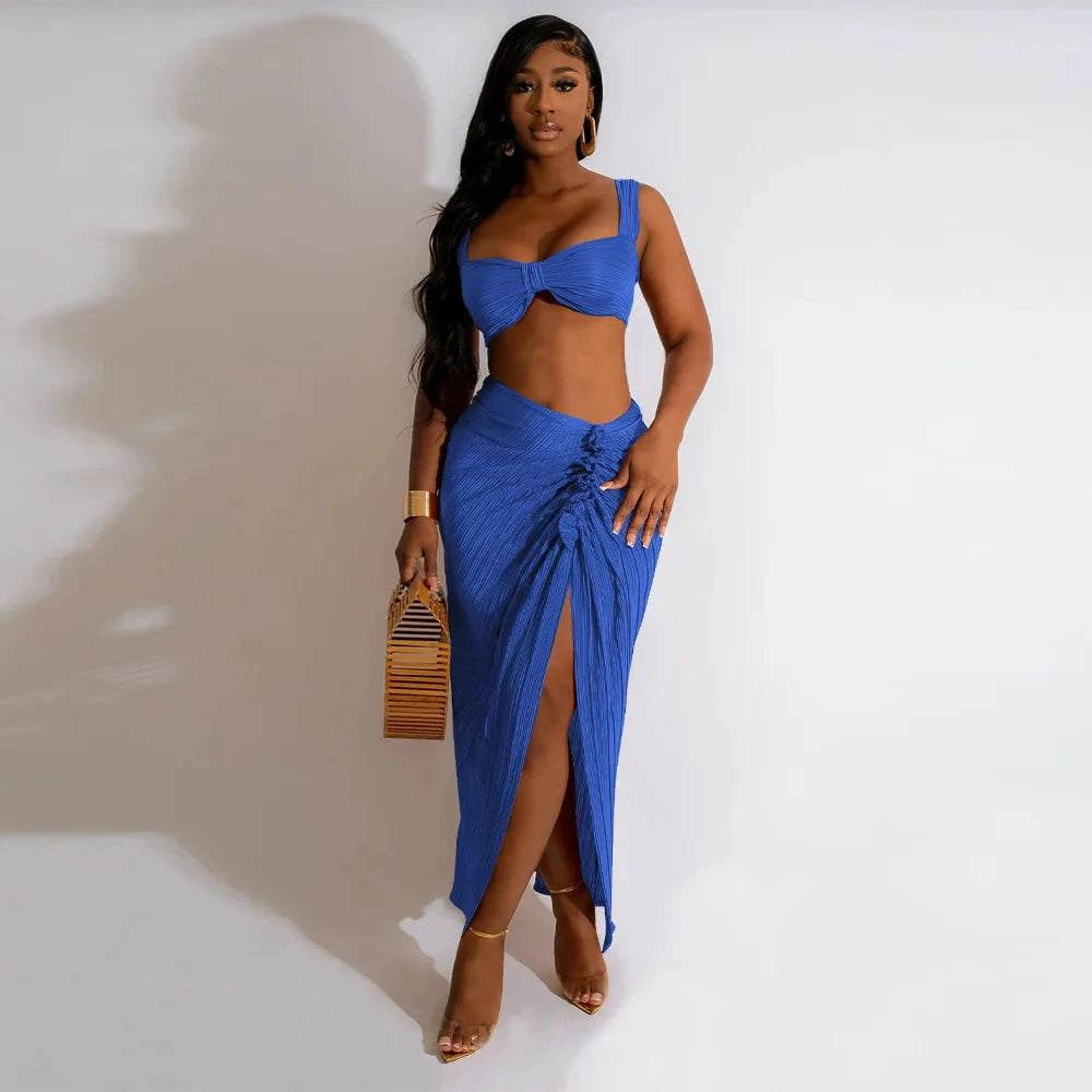 Two-piece set with backless halter top and high waist side slit pleated skirt in blue.