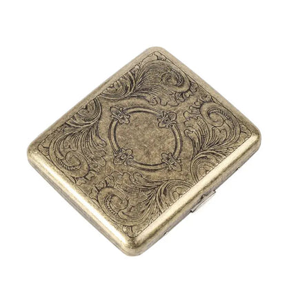 Retro brass cigarette box with ornate design.