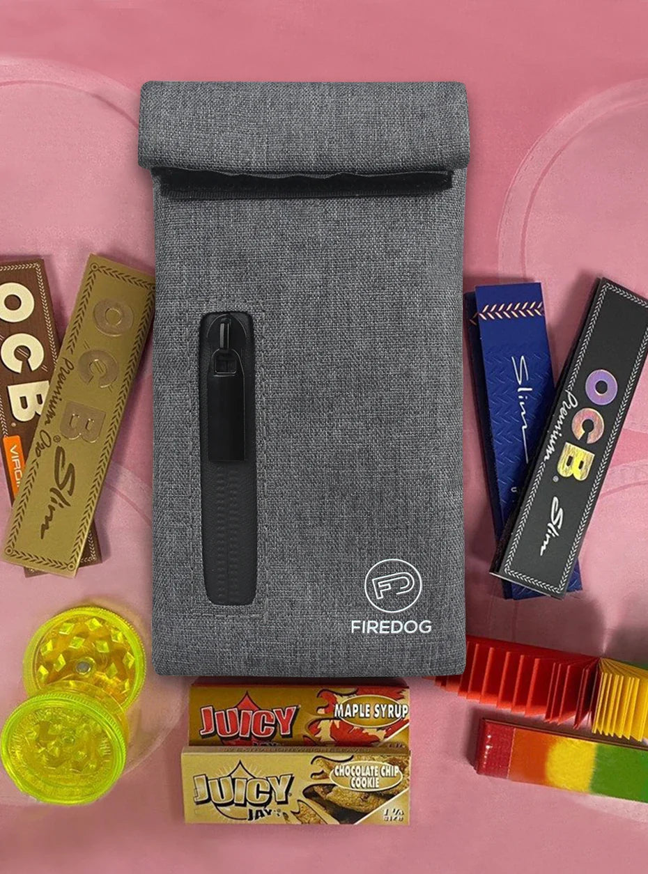 FIREDOG Smoking Smell Proof Pouch with Zipper, Carbon Lined PU Leather Herb Bag surrounded by smoking accessories.