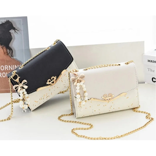 Set of stylish crossbody women's bags in black and white with gold pendant chain and pearl decoration