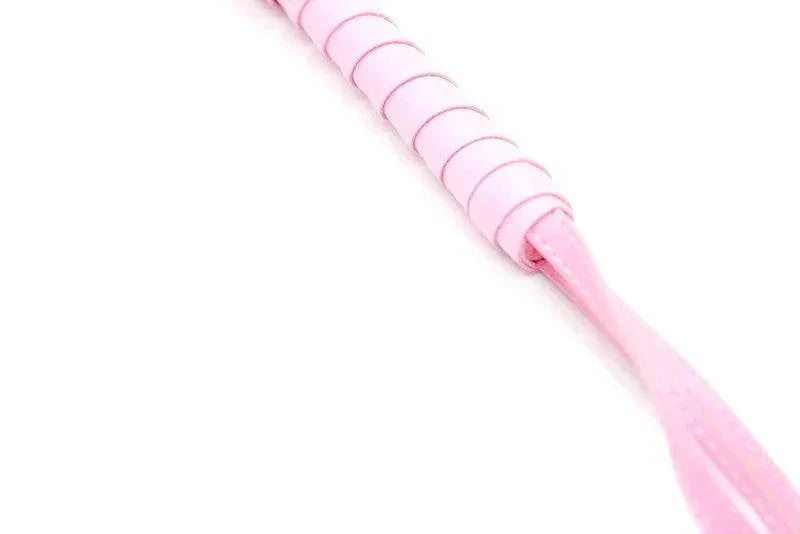 Pink BDSM bondage whip with leather handle for erotic accessories and fetish games.