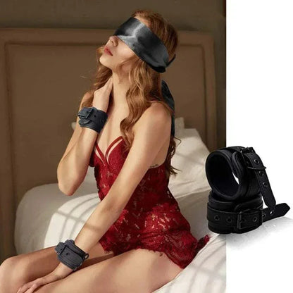 Erotic leather handcuffs and footcuffs set for couples on bed.