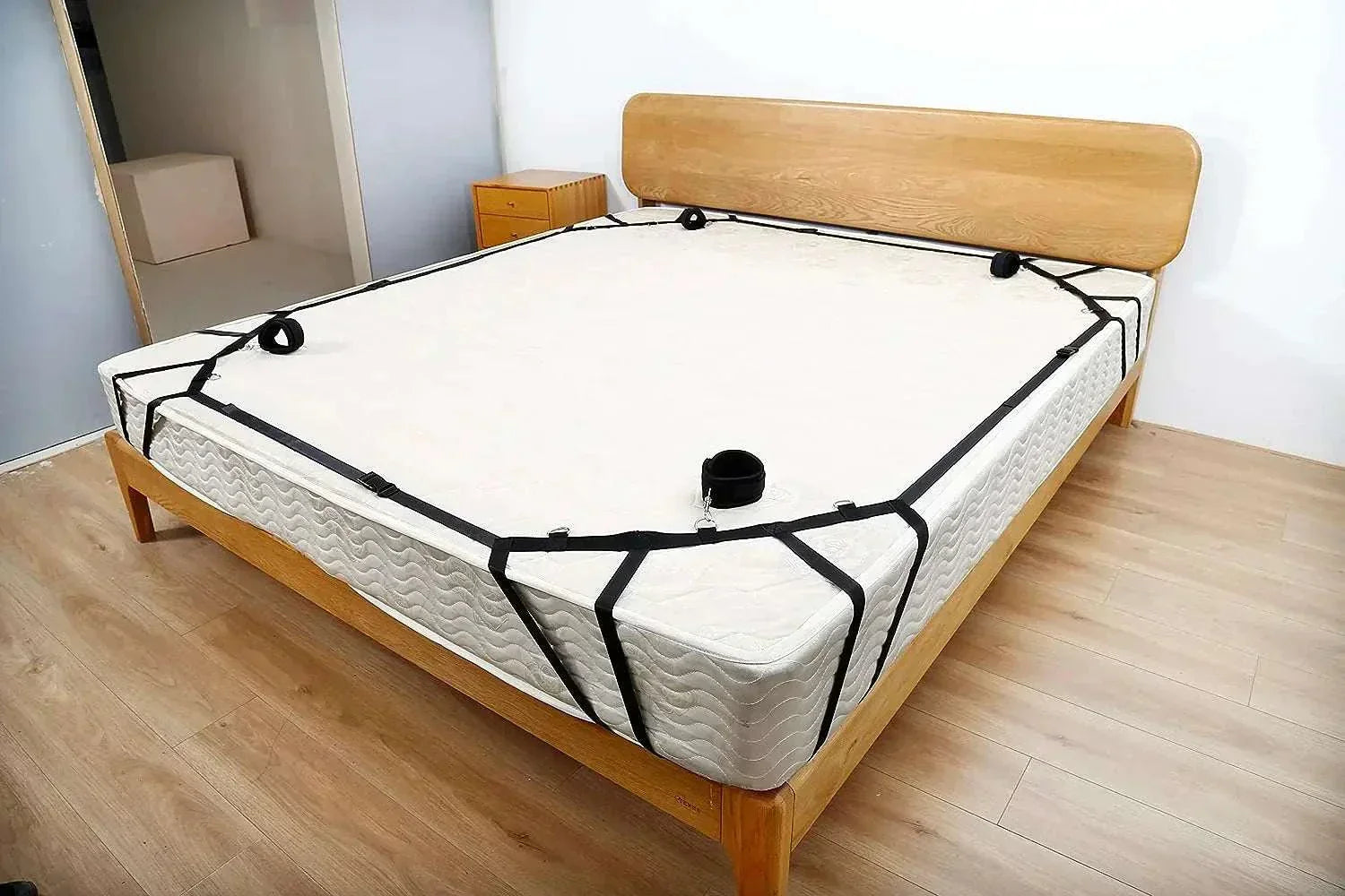 Nylon bed restraint system with handcuffs and ankle cuffs for couples' BDSM play.