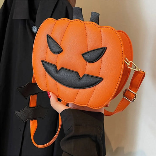 Orange Halloween pumpkin bag with black devilish face and bat wing strap detail, stylish crossbody purse for women and girls