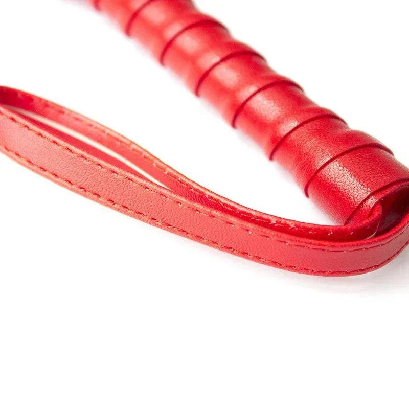 Red leather BDSM bondage whip with handle for fetish spanking and restraints.