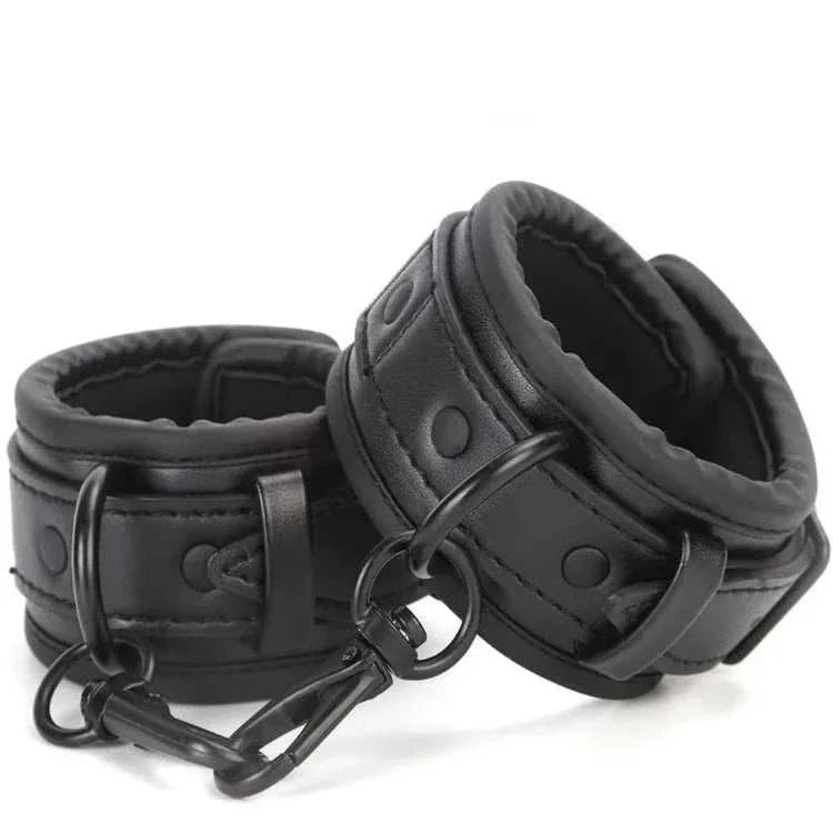 SM erotic leather handcuffs and footcuffs set for bondage binding in BDSM play.