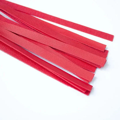 Red leather flogger whip for BDSM bondage and fetish play.