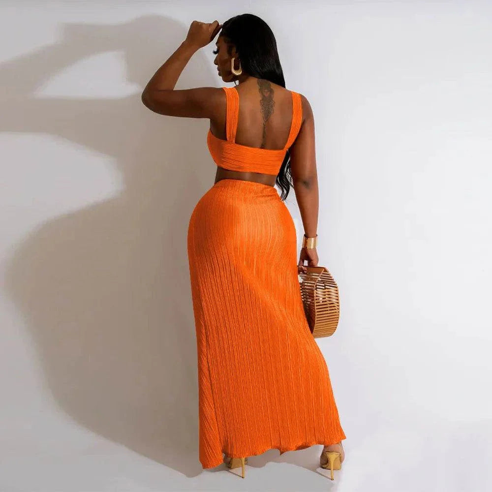 Two-piece summer dress set with backless halter top and high waist side slit pleated skirt, orange.