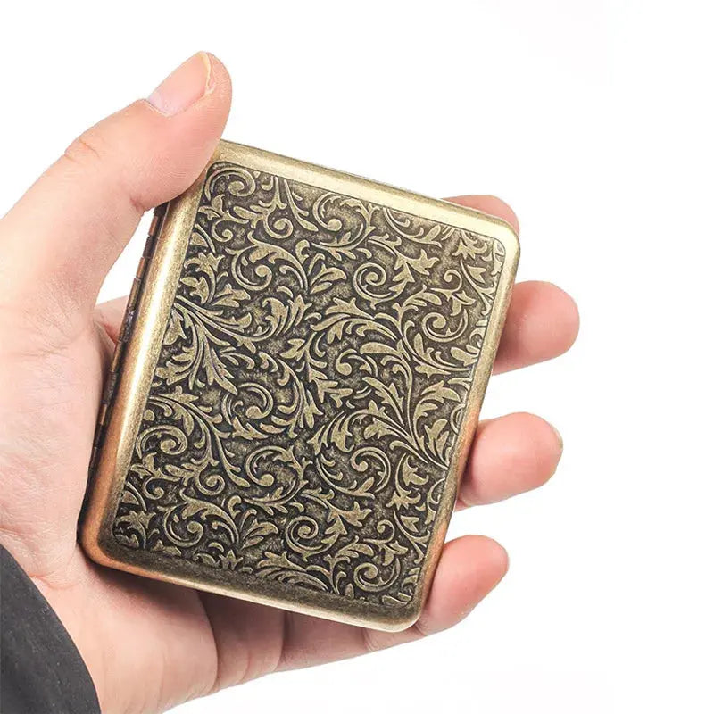Retro brass cigarette box with ornate frosted design, handheld size.