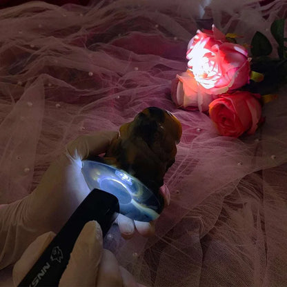 Multi-color QAAI hollow anal expander with liquid silicone, male wearable prostate massager, shown with roses and soft lighting.