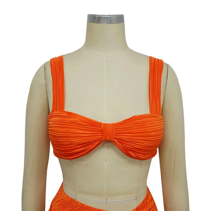 Orange backless halter top and high waist side slit pleated skirt set for women, perfect for spring and summer streetwear.