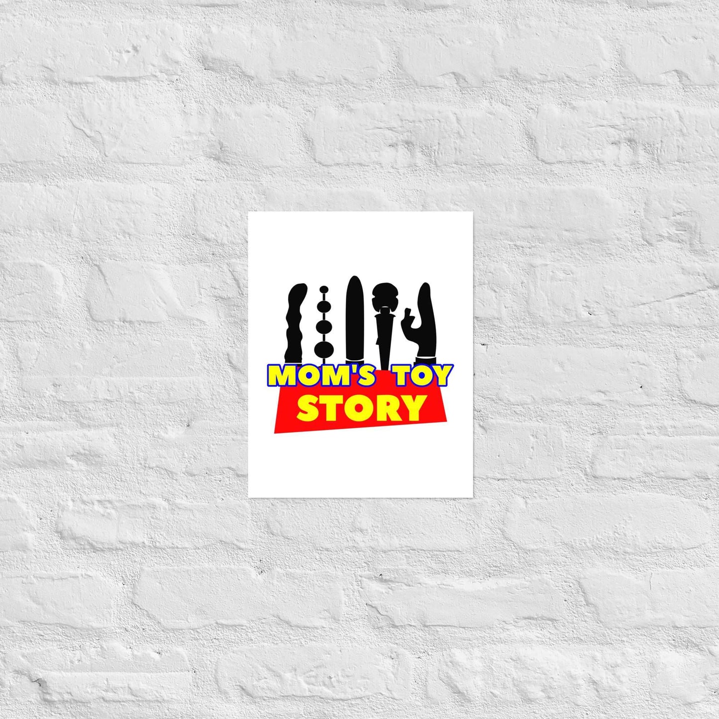 Museum-quality "Mom's Toy Poster" on thick matte paper against a white brick wall.