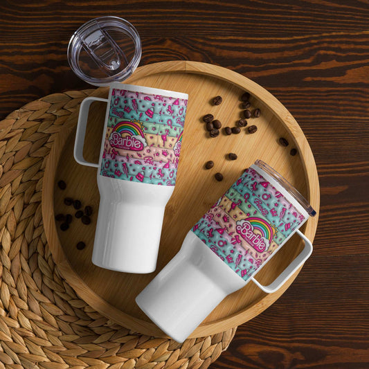 Two white travel mugs with handles featuring colorful Barbie designs and clear plastic lids on a wooden tray with scattered coffee beans