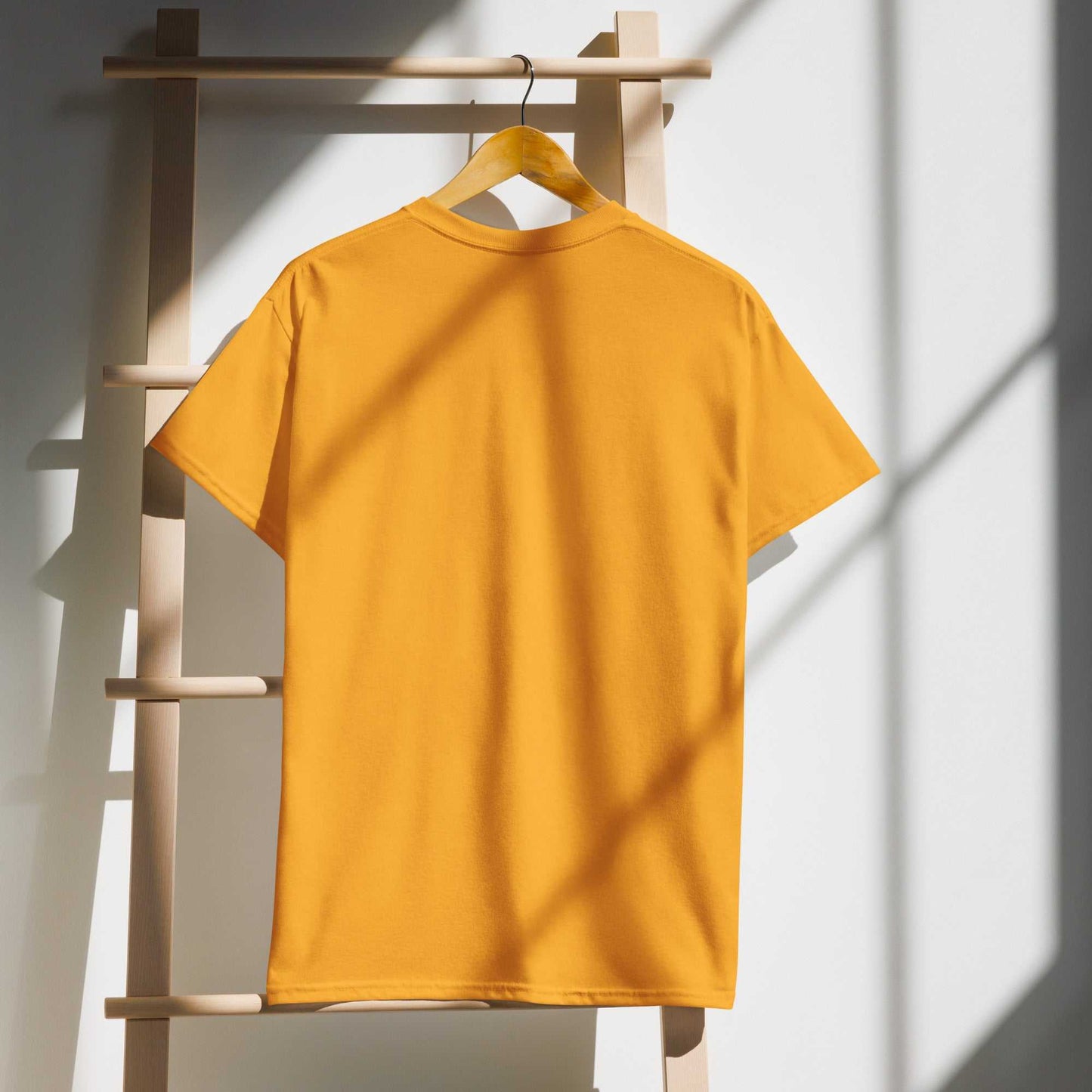 Yellow DryBlend® T-shirt hanging on a wooden rack.