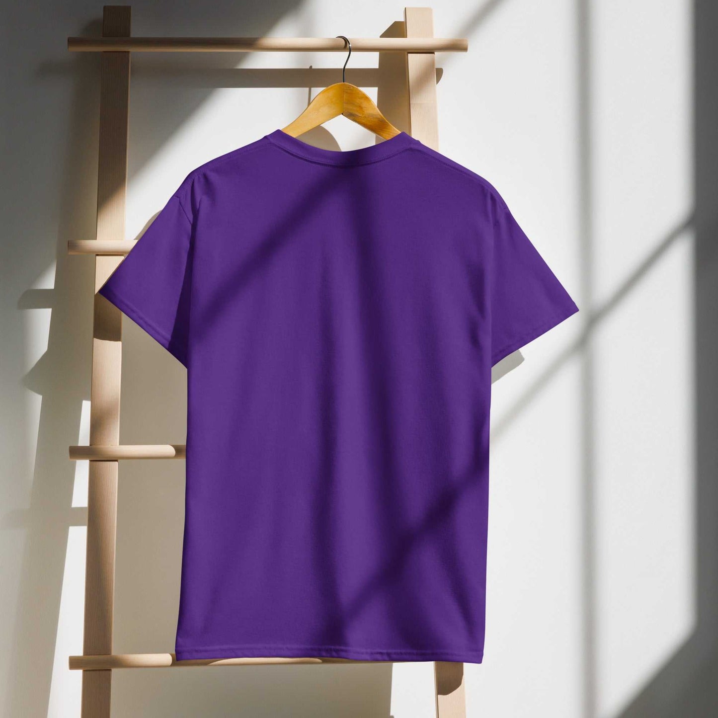 Purple Saggin Still Gaggin DryBlend T-Shirt on hanger with sunlight shadows.